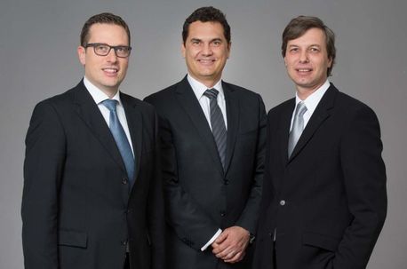 Drei Notare in dunklen Anzügen nebeneinander in Wien